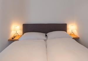 汉堡FirstClass Apartments的一间卧室,两边都配有一张床和两盏灯