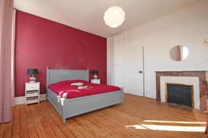 莱格勒Normandie 12 couchages的红色卧室设有一张床和一个壁炉