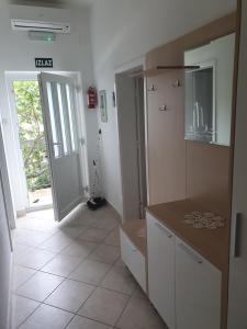 DrašniceApartments Jerković Drašnice-3bd的厨房配有白色橱柜,门通往走廊