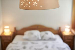 莱迪亚布勒雷Magnifique appartement aux Diablerets avec vue imprenable的一间卧室配有一张带毛巾和两张蜡烛的床。