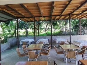 新阿丰Aparthotel na Abovyana 7的户外庭院配有桌椅和树木。