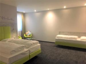 多瑙河畔迪林根SleepySleepy Hotel Dillingen的一间设有两张床和椅子的房间