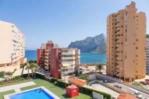 卡尔佩Apartamentos Entremares - Grupo Antonio Perles的城市中建筑物和游泳池的景色
