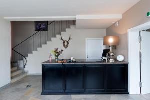 温特贝格Landhotel Flora & Fauna的厨房配有黑色橱柜和楼梯