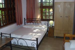 PantokratorasArt House的卧室配有床、桌子和窗户。