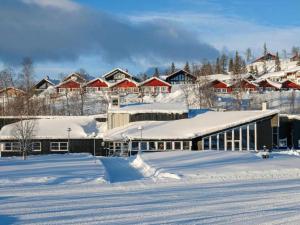 塔那比Tärnaby Sporthotell的一座被雪覆盖的建筑,房子的背景