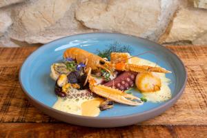 海瑞星阿莫斯昆塔尔别墅罗曼蒂克酒店的一块蓝色的盘子,上面有胡萝卜和其他蔬菜