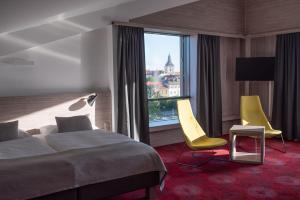 伊钦Hotel TAMMEL的酒店客房设有一张床、两把椅子和一扇窗户。