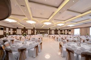 贝尔格莱德马吉安酒店的一个带白色桌椅的大型宴会厅