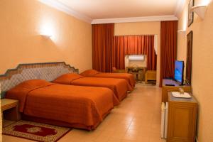 Afourer彻斯勒塔扎库特酒店的酒店客房设有两张床和电视。