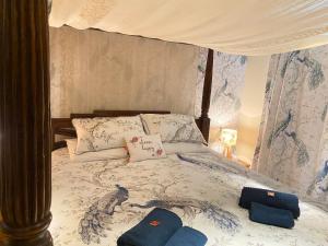 彭里斯Lake District romantic get away in 1 acre gardens off M6的一张带天蓬的床,上面有两个枕头