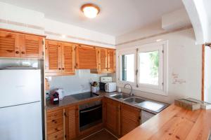 阿雷纳尔登卡斯特尔Villa ELSIE的厨房配有木制橱柜和白色冰箱。