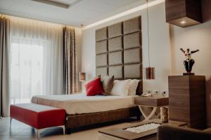 卡坦扎罗丽都尼亚加拉酒店的一间卧室配有一张大床和一张红色椅子