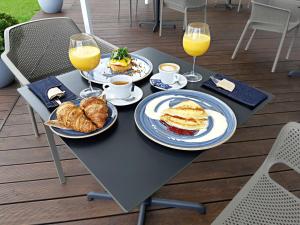 维尔纽斯乌比霍普酒店的一张桌子,上面放有盘子和两杯橙汁