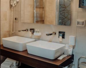 卡坦扎罗丽都尼亚加拉酒店的浴室设有白色水槽和镜子