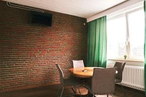 不莱梅Pension & Monteurwohnungen Burglesum Bremen的一间设有砖墙和桌椅的用餐室