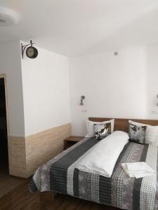 比斯特里察Sara House的一间卧室设有一张床和白色的墙壁