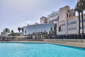 塞维利亚安达卢斯宫希尔肯酒店的大楼前的大型游泳池