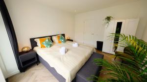 埃因霍温Luxury 60m2 Apartment with 20m2 Private Terrace的一间卧室配有一张带橙色枕头的大床