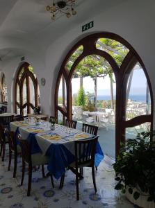 伊斯基亚帕尔科孔蒂酒店的一间用餐室,配有一张带蓝桌布的桌子