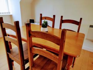 布里斯托17 Crusader House的一张带四把椅子的木桌和一盆盆盆栽植物