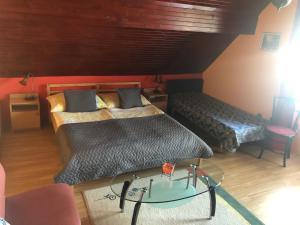 欧尔菲Anita Apartmanház的一间卧室配有两张床和一张玻璃桌