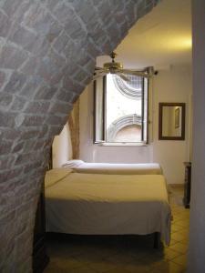 锡耶纳艾尔伯格卡那多罗酒店的一间卧室设有两张床和窗户。