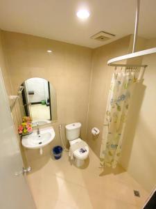 彭世洛Polkadot Hostel的一间带卫生间、水槽和镜子的浴室