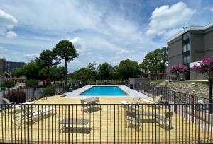 北小石城Country Inn & Suites by Radisson, North Little Rock, AR的一个带椅子和围栏的游泳池