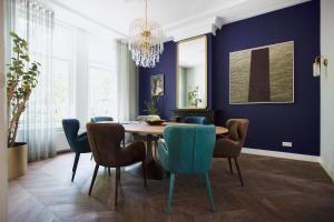 乌得勒支MUZE Hotel Utrecht的一间拥有蓝色墙壁和一张木桌及椅子的用餐室