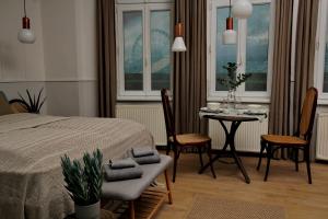 布达佩斯Gellerico Apartments Deák Square的卧室配有一张床和一张桌子及椅子
