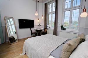 布达佩斯Gellerico Apartments Deák Square的一间卧室配有一张床和一张桌子及一台电视