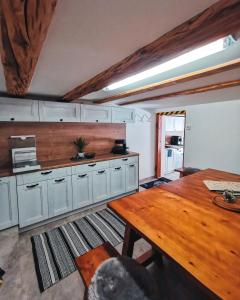 MeienGästehaus Alpenglühn的厨房配有白色橱柜和木桌