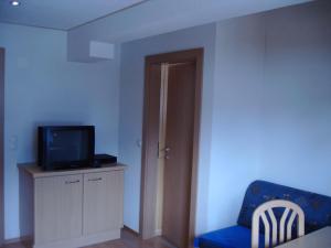 大格洛克纳山麓卡尔斯Haus Gartenheim的客厅配有电视和蓝椅
