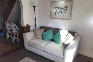 费克纳姆Attractive 2 bed cottage in Hempton Fakenham的客厅配有白色沙发及蓝色枕头