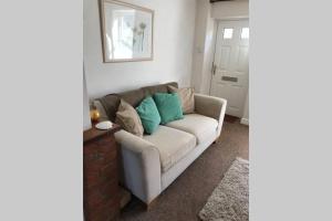 费克纳姆Attractive 2 bed cottage in Hempton Fakenham的客厅配有带蓝色枕头的沙发