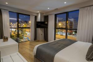 雅典The Convo Syngrou Apartments的一间卧室设有一张大床和一个大窗户