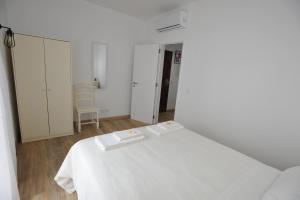 拉戈斯Lagos Central Apartments Ap 1的白色的客房配有一张床和椅子
