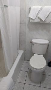 长滩金鹰汽车旅馆的白色的浴室设有卫生间和浴缸。