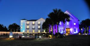 圣罗莎海滩30-A Inn & Suites的一座白色的大建筑,前面有圣诞灯