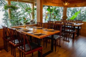 萨帕图博特尔沙巴旅馆的餐厅设有木桌、椅子和窗户。