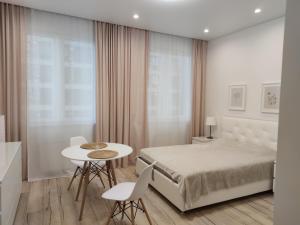 莫斯科Apartment on Smolnaya 44/1的卧室配有一张床和一张桌子及椅子