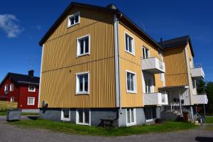 基律纳Apartment with shared bathroom in central Kiruna 2的一间大型黄色房子,在街上设有白色窗户