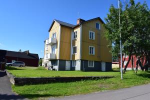 基律纳Apartment nr 1 with shared bathroom in Kiruna C - Paradise Lapland的街道边的黄色大房子