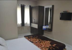 迪乌Premium hotel near Nagoa Beach的一间卧室配有一张床和一个带镜子的梳妆台