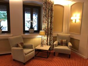 法克湖应赛尔伐科尔湖酒店的一间等候室,配有两把椅子和一张桌子,窗户