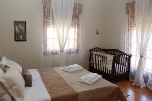 卡兰巴卡Meteoron Guesthouse的一间卧室配有一张床、一张婴儿床和窗户。