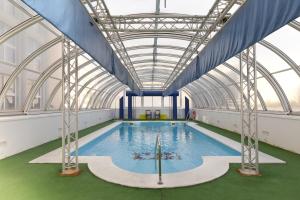 塞维利亚塞维利亚顶点酒店的一个带玻璃天花板的大型室内游泳池