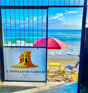 特拉比亚Castello di Sabbia的海滩美景,配有遮阳伞和标志