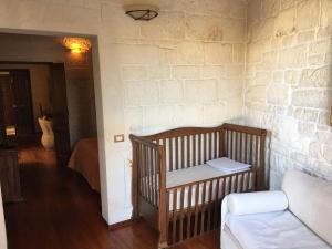 马丁纳弗兰卡B&B San Martino的砖墙前的一间有婴儿床的房间